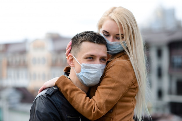 Paar, das eine Gesichtsmaske trägt, während es auf der Straße geht
