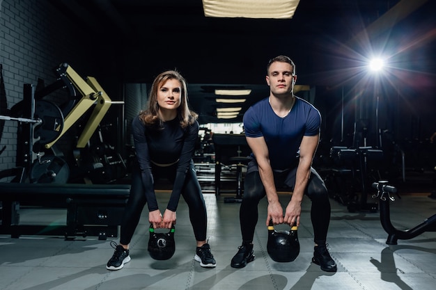 Paar, das Hanteln zusammen im Crossfit-Fitnessstudio hebt