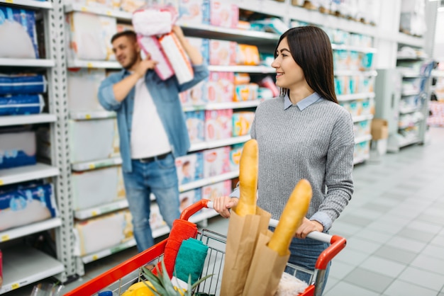 Foto paar, das viele windeln im supermarkt kauft