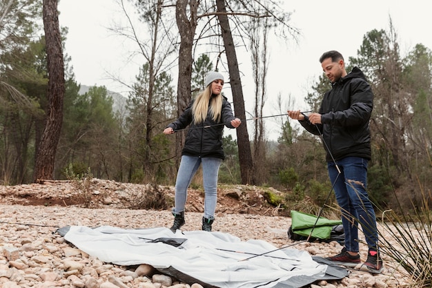 Foto paar, das zelt für camping vorbereitet