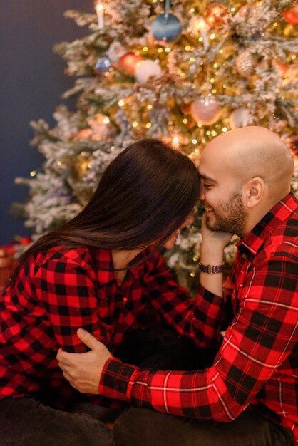 Paar, das zu Hause in Weihnachtsdekorationen umarmt