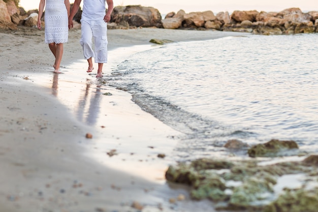 Paar, das zusammen am Strand entlang geht