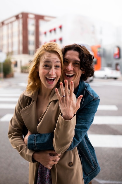 Paar draußen in der Stadt nach Heiratsantrag mit Verlobungsring