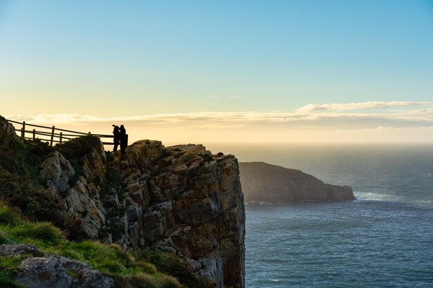 Paar ein Foto auf Klippen am Meer bei Sonnenuntergang Asturien Spanien