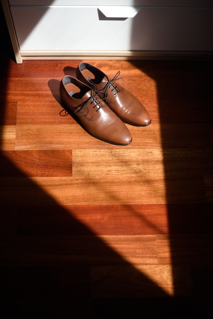 Paar elegante Schuhe im Schlafzimmer mit Fensterlicht