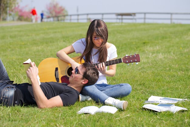 Paar entspannen und Gitarre spielen im Freien