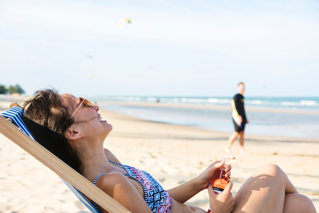 Foto paar entspannend mit bier am strand