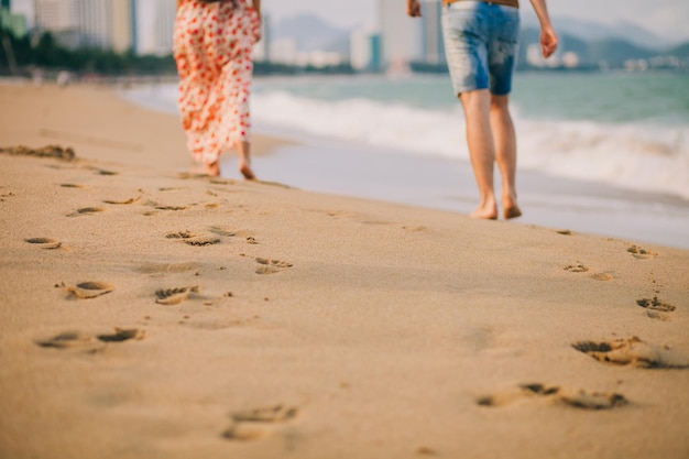 Paar geht gemeinsam am Strand spazieren. Stufen und Blick auf den Sandstrand