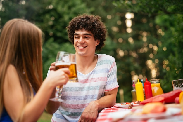 Paar genießt Biertrinken mit Freunden bei einem Picknick