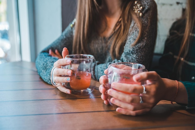 Foto paar hände von mädchen schließen frauen, die im café sprechen