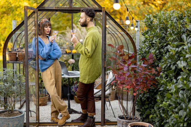 Paar hängt zusammen mit Wein im Garten ab