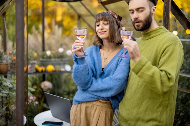 Paar hängt zusammen mit Wein im Garten ab