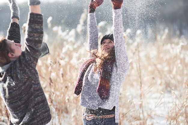 Paar hat Spaß und lacht. Kuss. Junge Hippie-Paare, die im Winterpark sich umarmen. Winterliebesgeschichte, ein schönes stilvolles junges Paar. Wintermode-Konzept mit Freund und Freundin