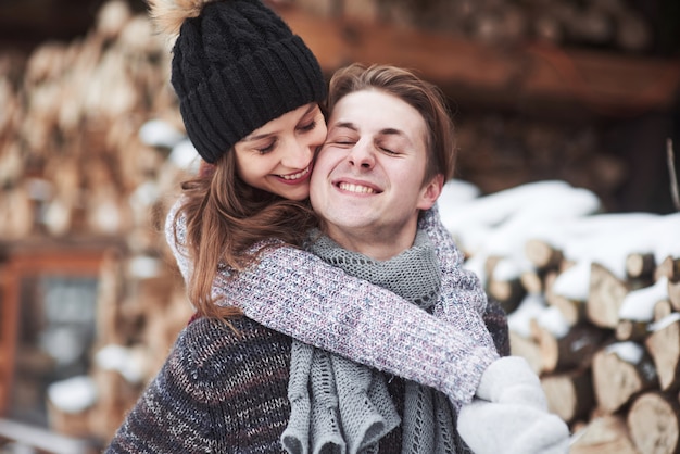 Paar hat Spaß und lacht. Kuss. Junges Hipsterpaar, das einander im Winterpark umarmt. Winterliebesgeschichte, ein schönes stilvolles junges Paar. Wintermode-Konzept mit Freund und Freundin