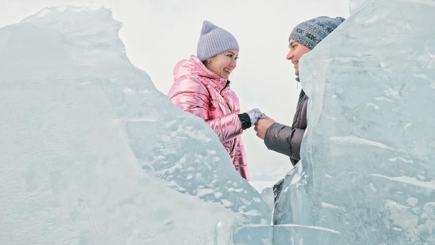 Paar hat Spaß während des Winterspaziergangs vor dem Hintergrund des Eises von f