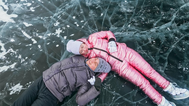 Paar hat Spaß während des Winterspaziergangs vor dem Hintergrund des Eises von f