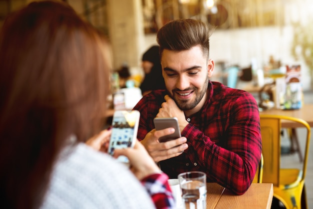 Paar im Café mit ihren Telefonen.