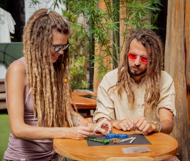Paar im Hippie-Stil, das medizinische Marihuana-Zigaretten herstellt