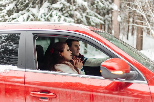 Paar im roten Auto auf ihrer Urlaubsreise