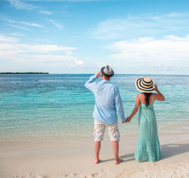 Paar im Urlaub zu Fuß an einem tropischen Strand Malediven. Romantischer Spaziergang von Mann und Frau am Strand.