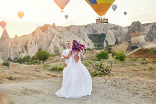 Paar in der Liebe steht auf Hintergrund von Ballonen in Cappadocia