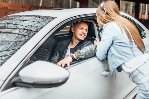 Paar in der Nähe von Auto. Mann fährt zur Arbeit und seine Frau wird ihn warten.