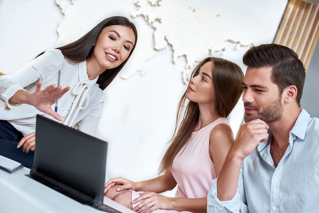 Paar in einem Reisebüro, das eine Tour mit einem Reisebüro auswählt