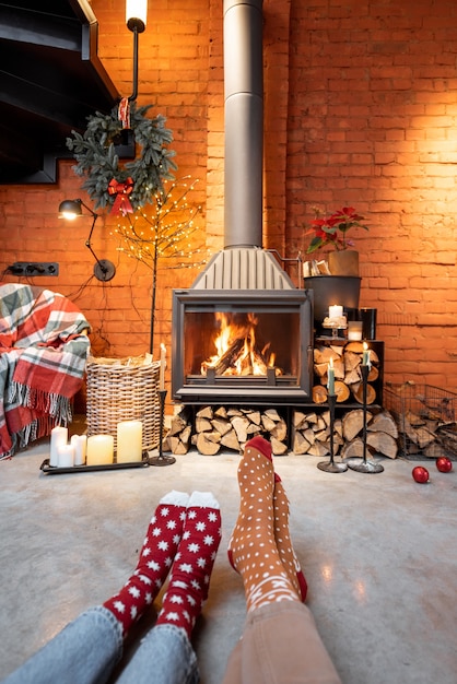 Paar in Weihnachtssocken am Kamin zu Hause. Das Konzept des Komforts während der Winter- und Neujahrsferien