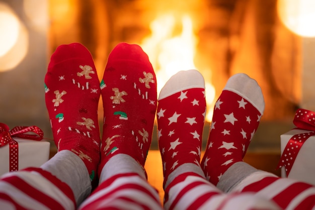 Paar in Weihnachtssocken in der Nähe des Kamins Mann und Frau, die zusammen Spaß haben Menschen, die sich zu Hause entspannen