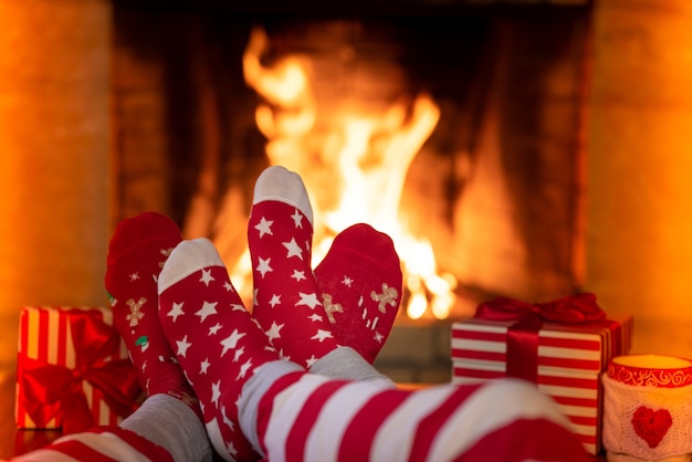 Paar in Weihnachtssocken in der Nähe des Kamins Mann und Frau, die zusammen Spaß haben Menschen, die sich zu Hause entspannen