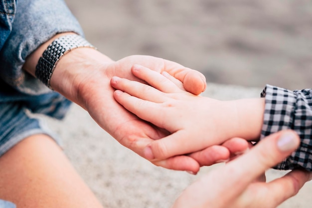 Paar kaukasische Hände, die mit Zärtlichkeit und Süße unter der Sonne zusammenkommen Liebe und Schutz Mutter-Sohn-Konzept Hände auf Hände für Liebesbild