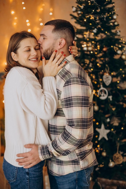 Paar küssen sich am Weihnachtsbaum