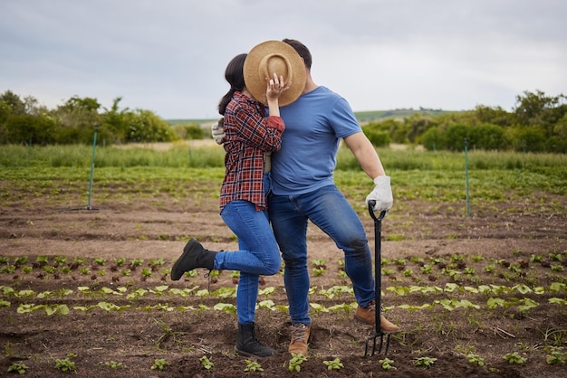 Paar küsst Landwirtschaft Bauer oder Gartenarbeiter auf dem Feld Nachhaltigkeit Natur oder Wachstumslandschaft Verbindet romantische und lustige Männer und Frauen, die mit Umweltpflanzen und Erdboden arbeiten