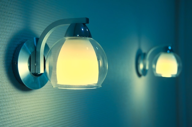 Paar Lampenlichter im Schlafzimmer. Das Blau- und Gelbtonbild von zwei Nachtlampen.