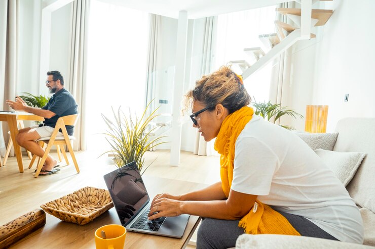 Foto paar lebensstil zu hause mit laptop modernes neues geschäftskonzept eine frau mit computer sitzt auf dem sofa und mann im hintergrund am tisch wohnung indoor freizeit hotelzimmer reisen menschen