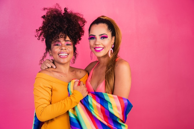 Paar lesbische Frau mit Gay-Pride-Flagge im gelben Hintergrund