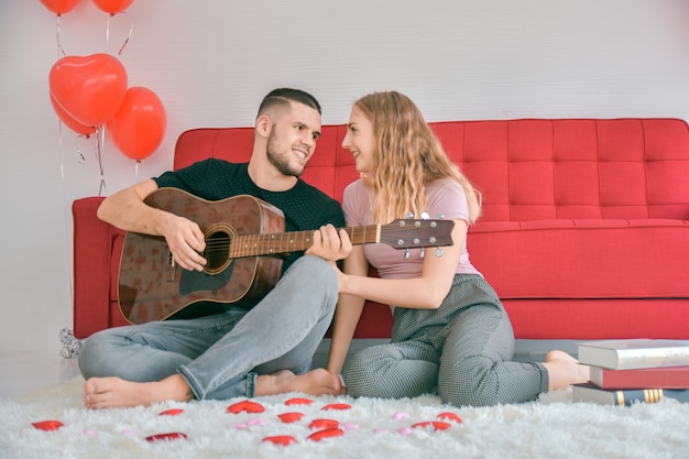 Paar Liebe Gitarre spielen im Schlafzimmer Liebe im Valentinstag Konzept