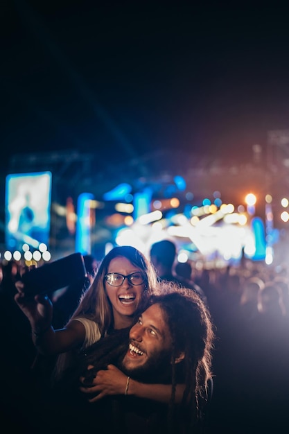 Paar macht Selfie mit einem Smartphone auf einem Musikfestival