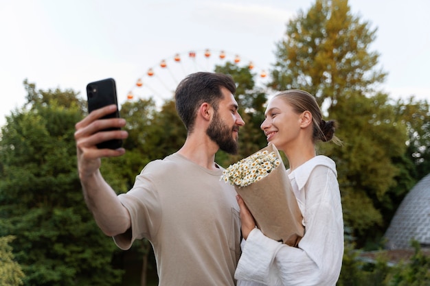 Paar macht Selfie, während es gemeinsam am Riesenrad unterwegs ist