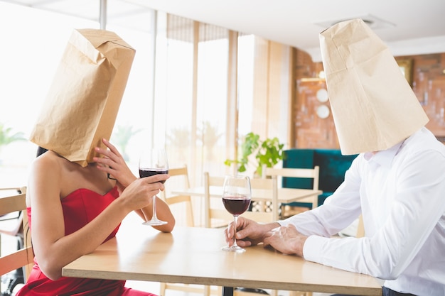 Paar mit braunen Papiertüten über den Köpfen