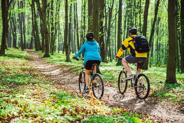 Paar mit Fahrrad im Wald an warmen Tagen