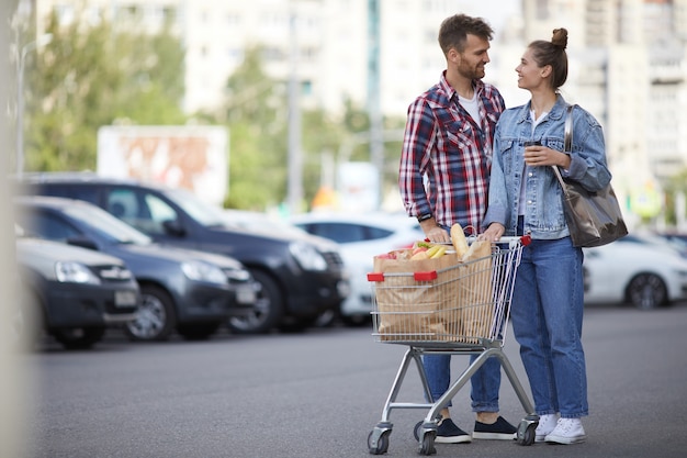 Paar mit Lebensmitteln auf dem Parkplatz