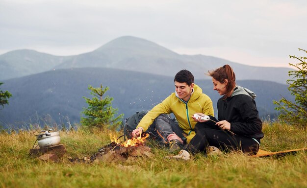 Paar mit Marshmallow in der Nähe von Lagerfeuer Majestätische Karpaten Schöne Landschaft unberührter Natur