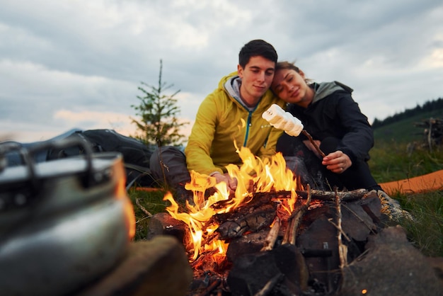 Paar mit Marshmallow in der Nähe von Lagerfeuer Majestätische Karpaten Schöne Landschaft unberührter Natur