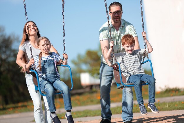 Paar mit zwei Kindern, die auf dem Spielplatz spielen