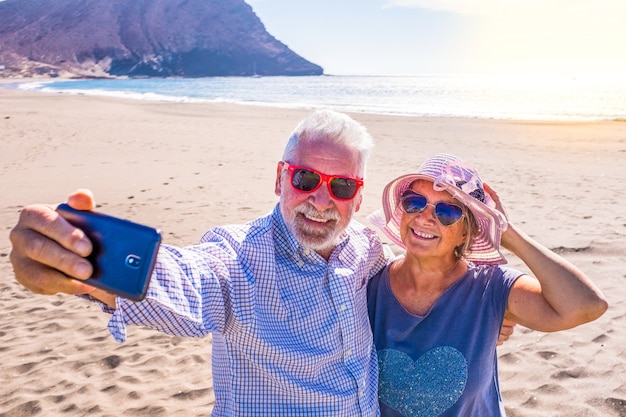 Paar reife Leute oder Rentner, die ihren Urlaub und die Sommerzeit zusammen auf dem Sand genießen