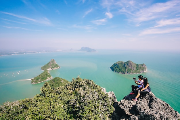 Paar Reisender machen Foto auf den Berg und genießen für einen wunderschönen Blick aufs Meer