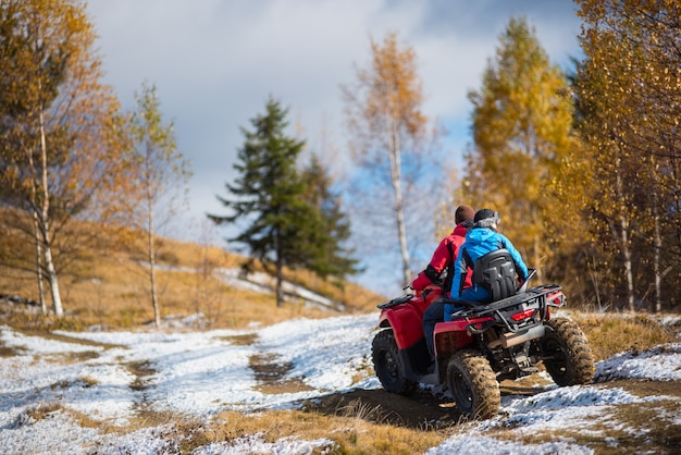 Paar Reiten auf Quad-Bike auf verschneiten Straßen