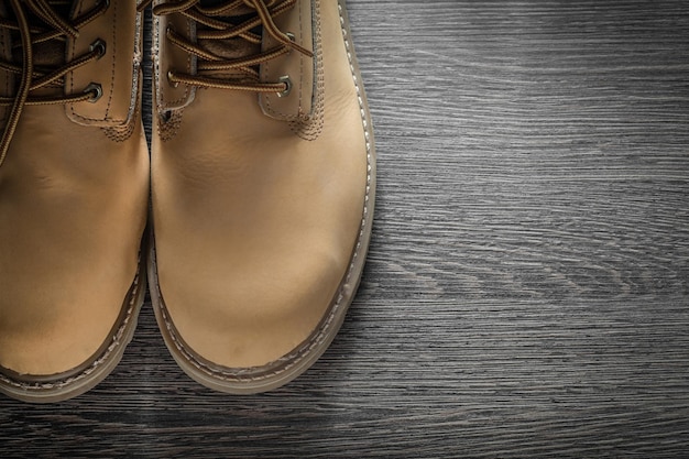 Paar Sicherheitsstiefel aus Leder auf Holzbrett