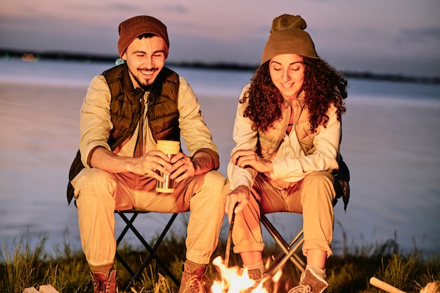 Paar sitzt am Lagerfeuer